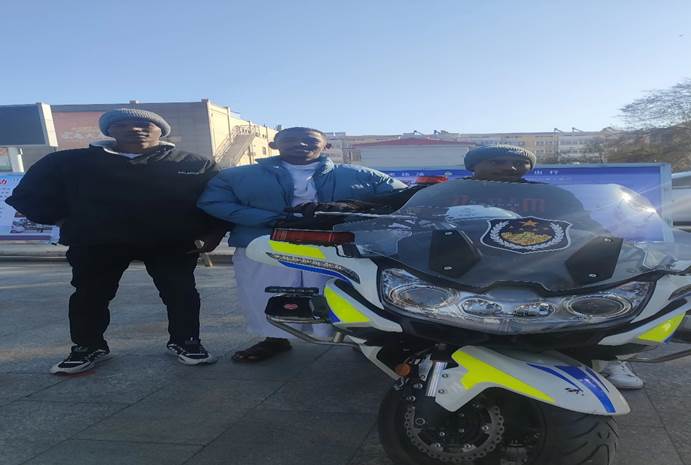 男人站在摩托车边中度可信度描述已自动生成 男人站在摩托车边中度可信度描述已自动生成